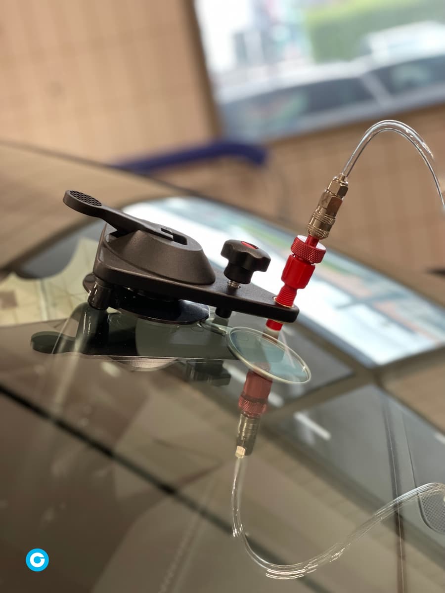 Pont d'injection à ventouse posé sur un pare-brise pour réparer un impact sous vide